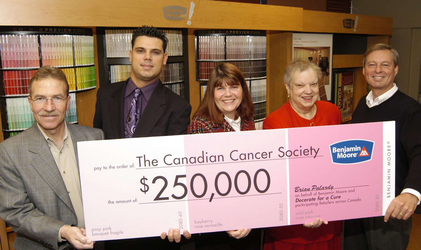 Colour Land Paint presenting a $250,000 Canadian Cancer Society donation cheque with Benjamin Moore's Decorate for a Cure program